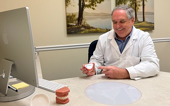 Orthodontist P. Todd Bonner Pointing To Plastic Teeth Mold